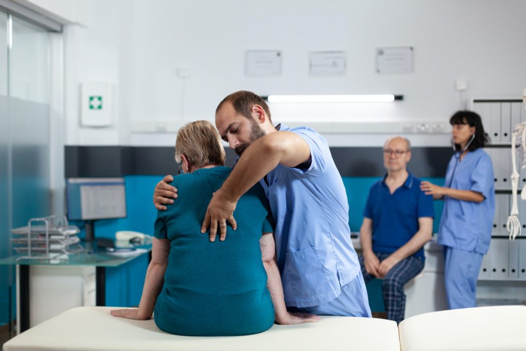 Medical assistant treating woman with back and spine pain