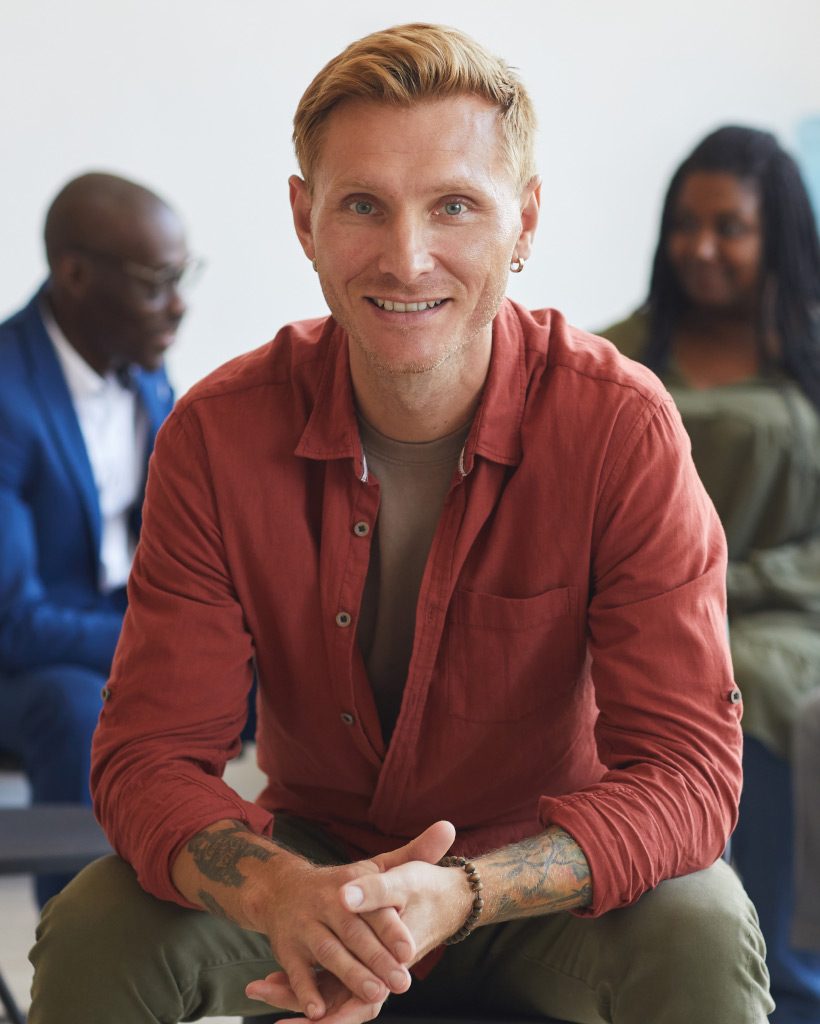 smiling-man-at-group-therapy-session-7HU8Q2C