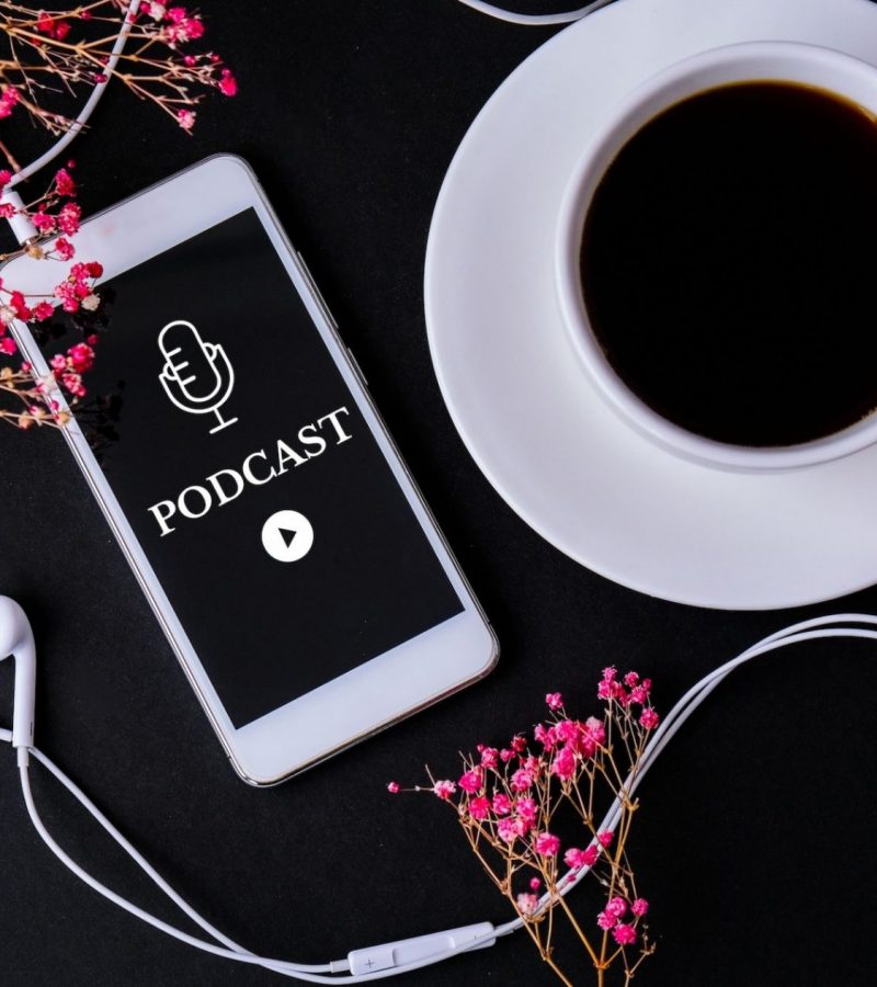 Mobile phone podcast with headphones on workplace. Listening to podcast. Audiobook. Online education