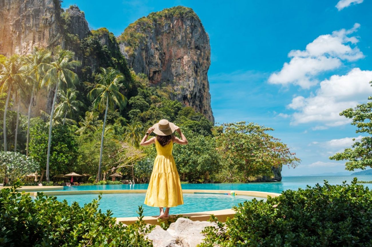 Woman tourist in yellow dress and hat traveling on Railay beach, Krabi, Thailand. vacation, travel